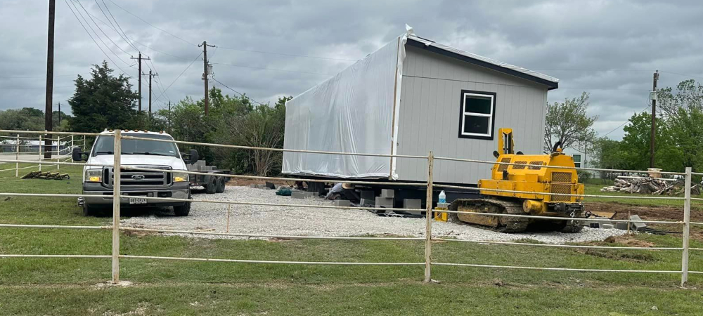 A half of a mobile home that has had a new driveway paved in